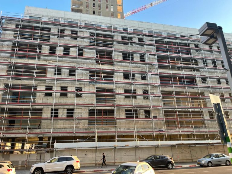 פיגום חזית על בניין מגורים בבנייה, מבט מהרחוב